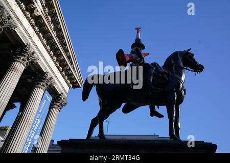 Die Statue des Duke of Wellington vor der Gallery of Modern Art in Glasgow, die mit einem neuen Verkehrskegel verziert wurde - mit einem schwarzen Streifen und einem Propeller auf der Oberseite. Es gibt Spekulationen, dass die neueste Ergänzung der berühmten Statue von Glasgow eingerichtet wurde, um das Ende der Banksy-Ausstellung „Cut and Run“ zu feiern, die am Montag geschlossen wurde. Bilddatum: Mittwoch, 30. August 2023. Stockfoto