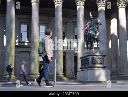 Die Statue des Duke of Wellington vor der Gallery of Modern Art in Glasgow, die mit einem neuen Verkehrskegel verziert wurde - mit einem schwarzen Streifen und einem Propeller auf der Oberseite. Es gibt Spekulationen, dass die neueste Ergänzung der berühmten Statue von Glasgow eingerichtet wurde, um das Ende der Banksy-Ausstellung „Cut and Run“ zu feiern, die am Montag geschlossen wurde. Bilddatum: Mittwoch, 30. August 2023. Stockfoto