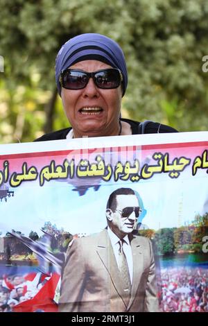 (140813) -- KAIRO, 13. August 2014 -- Ein Unterstützer des ehemaligen ägyptischen Präsidenten Hosni Mubarak schreit, während er ein Poster des ehemaligen Präsidenten außerhalb des Maadi Militärkrankenhauses in Kairo, Ägypten, hält, 13. August 2014. Der ehemalige ägyptische Präsident Hosni Mubarak sagte am Mittwoch vor Gericht, dass er während des Volksaufstandes 2011 gegen seine langjährige Herrschaft keine Anweisung gab, Demonstranten zu töten, berichtete der staatliche Nile TV. (srb) ÄGYPTEN-KAIRO-MUBARAK-PROZESS AhmedxGomaa PUBLICATIONxNOTxINxCHN Kairo 13. August 2014 ein Unterstützer des ehemaligen ägyptischen Präsidenten Hosni Mubarak schreit, während er ein Poster des ersteren hält Stockfoto