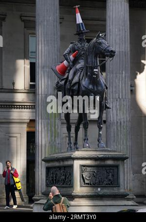 Die Statue des Duke of Wellington vor der Gallery of Modern Art in Glasgow, die mit einem neuen Verkehrskegel verziert wurde - mit einem schwarzen Streifen und einem Propeller auf der Oberseite. Es gibt Spekulationen, dass die neueste Ergänzung der berühmten Statue von Glasgow eingerichtet wurde, um das Ende der Banksy-Ausstellung „Cut and Run“ zu feiern, die am Montag geschlossen wurde. Bilddatum: Mittwoch, 30. August 2023. Stockfoto