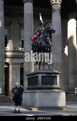 Die Statue des Duke of Wellington vor der Gallery of Modern Art in Glasgow, die mit einem neuen Verkehrskegel verziert wurde - mit einem schwarzen Streifen und einem Propeller auf der Oberseite. Es gibt Spekulationen, dass die neueste Ergänzung der berühmten Statue von Glasgow eingerichtet wurde, um das Ende der Banksy-Ausstellung „Cut and Run“ zu feiern, die am Montag geschlossen wurde. Bilddatum: Mittwoch, 30. August 2023. Stockfoto