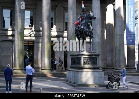 Die Statue des Duke of Wellington vor der Gallery of Modern Art in Glasgow, die mit einem neuen Verkehrskegel verziert wurde - mit einem schwarzen Streifen und einem Propeller auf der Oberseite. Es gibt Spekulationen, dass die neueste Ergänzung der berühmten Statue von Glasgow eingerichtet wurde, um das Ende der Banksy-Ausstellung „Cut and Run“ zu feiern, die am Montag geschlossen wurde. Bilddatum: Mittwoch, 30. August 2023. Stockfoto