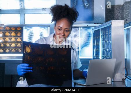 Medizinische Radiologin-Ärztin schaut Kopf- und Hirnröntgenfilm vor der Operation in der Laborpraxis des Krankenhauses. Gesundheitswesen und Bildung. Stockfoto