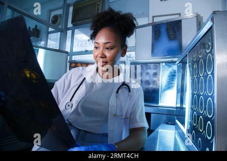 Medizinische Radiologin-Ärztin schaut Kopf- und Hirnröntgenfilm vor der Operation in der Laborpraxis des Krankenhauses. Gesundheitswesen und Bildung. Stockfoto