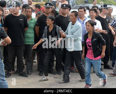 (140815) -- JIXI, 15. August 2014 -- Verwandte von eingeschlossenen Bergleuten sind begierig, gerettete Menschen außerhalb einer überfluteten Kohlemine der privaten Anzhishun-Kohlemine in Jixi, nordöstliche Provinz Heilongjiang, 15. August 2014, zu sehen. Neun Menschen wurden gerettet und 16 blieben im überfluteten Kohlebergwerk gefangen. ) (lfj) CHINA-HEILONGJIANG-JIXI-flooded COAL MINE RESCUE (CN) WangxKai PUBLICATIONxNOTxINxCHN Jixi 15. August 2014 Verwandte von Gefangenen Bergleuten sind begierig auf Berühmtheiten aus dem See außerhalb einer überfluteten Kohlemine der eigenen Kohlemine in Jixi Nordostchina, Provinz Heilongjiang, 15. August 2014 Stockfoto