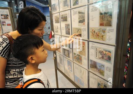 (140816) -- NANJING, August 16,2014 -- Eltern bringen Kinder bei den Olympischen Jugendspielen Nanjing 2014 in Nanjing, der Hauptstadt der ostchinesischen Provinz Jiangsu, am 16. August 2014 in philatelistische Gegenstände, die Radfahren enthalten. ) (Ljr) (SP)YOG-CHINA-NANJING-GEDENKMARKE SunxCan PUBLICATIONxNOTxINxCHN NANJING 16. August 2014 Eltern nehmen Kinder um philatelistische Gegenstände mit Radfahren BEI DEN Jugendolympischen Spielen in Nanjing 2014 in Nanjing Hauptstadt der ostchinesischen Provinz Jiangsu AM 16. August 2014 SP YOG China Nanjing Gedenktafel PUBLNxCHINN Stockfoto