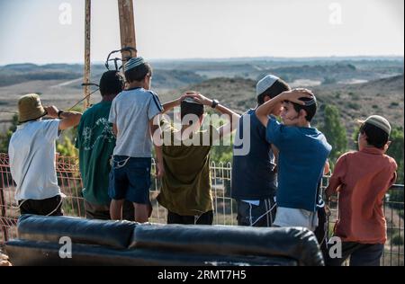 (140820) -- GAZA BORDER, 20. August 2014 -- jüdische Jugendliche schauen sich den Gazastreifen am 20. August 2014 von Sderot, Süd-Israel an der Grenze zum Gazastreifen an. Israel werde die Offensive im Gazastreifen verstärken, bis der Raketenabwurf von dort auf Israel aufhört, sagte Premierminister Benjamin Netanjahu am Mittwoch, als Reaktion auf die erneuten Gaza-Raketenangriffe auf Zentral- und Südisrael zu Beginn des Tages. ) ISRAEL-GAZA-OFFENSIVE-AUFSTOCKUNG LixRui PUBLICATIONxNOTxINxCHN Gaza-Grenze 20. August 2014 Jüdische Teenager Blick AUF den Gaza-Streifen von Sderot Süd-Israel grenzt AM 20. August 2014 an den Gaza-Streifen Israel Stockfoto