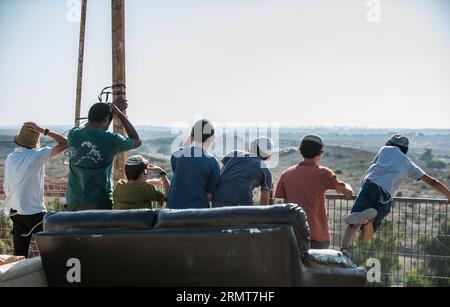 (140820) -- GAZA BORDER, 20. August 2014 -- jüdische Jugendliche schauen sich den Gazastreifen am 20. August 2014 von Sderot, Süd-Israel an der Grenze zum Gazastreifen an. Israel werde die Offensive im Gazastreifen verstärken, bis der Raketenabwurf von dort auf Israel aufhört, sagte Premierminister Benjamin Netanjahu am Mittwoch, als Reaktion auf die erneuten Gaza-Raketenangriffe auf Zentral- und Südisrael zu Beginn des Tages. ) ISRAEL-GAZA-OFFENSIVE-AUFSTOCKUNG LixRui PUBLICATIONxNOTxINxCHN Gaza-Grenze 20. August 2014 Jüdische Teenager Blick AUF den Gaza-Streifen von Sderot Süd-Israel grenzt AM 20. August 2014 an den Gaza-Streifen Israel Stockfoto