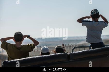 (140820) -- GAZA BORDER, 20. August 2014 -- jüdische Jugendliche schauen sich den Gazastreifen am 20. August 2014 von Sderot, Süd-Israel an der Grenze zum Gazastreifen an. Israel werde die Offensive im Gazastreifen verstärken, bis der Raketenabwurf von dort auf Israel aufhört, sagte Premierminister Benjamin Netanjahu am Mittwoch, als Reaktion auf die erneuten Gaza-Raketenangriffe auf Zentral- und Südisrael zu Beginn des Tages. ) ISRAEL-GAZA-OFFENSIVE-AUFSTOCKUNG LixRui PUBLICATIONxNOTxINxCHN Gaza-Grenze 20. August 2014 Jüdische Teenager Blick AUF den Gaza-Streifen von Sderot Süd-Israel grenzt AM 20. August 2014 an den Gaza-Streifen Israel Stockfoto