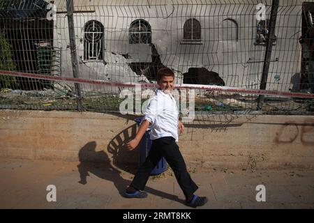 (140822) -- GAZA-GRENZE, 22. August 2014 -- ein israelisches Kind läuft an einer beschädigten jüdischen Synagoge vorbei, die am 22. August 2014 von einer Rakete aus dem Gazastreifen in Ashdod, der südisraelischen Stadt an der Grenze zu Gaza, getroffen wurde. Ein vierjähriger Junge wurde am Freitagabend durch einen Mörserangriff auf Südisrael getötet, sagte Magen David Adom, Israels Rotes Kreuz, Xinhua. JINI/) ISRAEL-ASHDOD-GAZA-RAKETENANGRIFF AlbertxSadikov PUBLICATIONxNOTxINxCHN Gaza-Grenze 22. August 2014 zu Israeli Child geht an einer beschädigten jüdischen Synagoge vorbei, die von einer Rakete getroffen wurde, die vom Gazastreifen in Ashdod in der südlichen israelischen Stadt an dem Ring Gaza AUF Au gestartet wurde Stockfoto