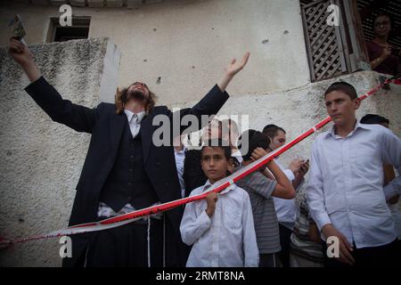 (140822) -- GAZA BORDER, 22. August 2014 -- orthodoxe Juden reagieren neben einer jüdischen Synagoge, die am 22. August 2014 von einer Rakete aus dem Gazastreifen in Ashdod, der südisraelischen Stadt an der Grenze zu Gaza, getroffen wurde. Ein vierjähriger Junge wurde am Freitagabend durch einen Mörserangriff auf Südisrael getötet, sagte Magen David Adom, Israels Rotes Kreuz, Xinhua. JINI/) ISRAEL-ASCHDOD-GAZA-RAKETENANGRIFF AlbertxSadikov PUBLICATIONxNOTxINxCHN Gaza-Grenze 22. August 2014 Orthodoxe Juden reagieren auf eine jüdische Synagoge, die AM 22. August 2014 von einer Rakete aus dem Gazastreifen in Aschdod getroffen wurde Stockfoto