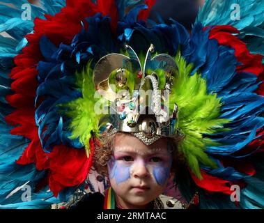 LONDON, 24. August 2014 -- Ein kleiner Künstler zieht während des Notting Hill Carnival in London, Großbritannien, am 24. August 2014 durch die Straßen. Der Notting Hill Carnival ist das größte Straßenfest in Europa und wurde erstmals 1964 von der afro-karibischen Gemeinschaft veranstaltet. Während des Feiertagswochenendes werden die Straßen zu Bands, farbenfrohen Wagen und kostümierten Darstellern lebendig, während Mitglieder der Öffentlichkeit in die Gegend strömen, um an den Feierlichkeiten teilzunehmen. ) UK-LONDON-NOTTING HILL CARNIVAL-CHILDREN S DAY PARADE HanxYan PUBLICATIONxNOTxINxCHN London 24. August 2014 ein kleiner Performer zieht durch die Stree Stockfoto