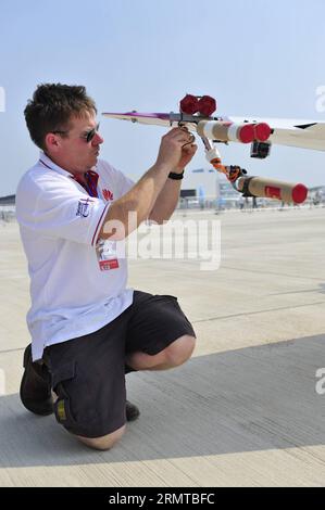 (140827) -- SHENYANG, 27. August 2014 -- Peter Wells, der mit dem Twister-Kunstflugteam zusammenarbeitet, bringt pyrotechnische Emitter aus der Luft an ein Silence SA1100-Flugzeug, bevor sein Team während der Shenyang Faku International Flight Convention 2014, einer Flugshow, in Shenyang, der Hauptstadt der nordöstlichen Provinz Liaoning, am 27. August 2014 Stunt-Performance erlebte. Die Twister, ein britisches Kunstflugteam, machte ihre erste Stunt-Performance in China bei der Eröffnungszeremonie der Shenyang Faku International Flight Convention am 27. August 2014. Der Twister wurde 2010 von Peter Wells gegründet, der aus einem Segelflugzeug stammt Stockfoto