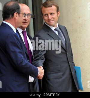 (140827) -- PARIS, 27. August 2014 -- der französische Präsident Francois Hollande (L) und der französische New Economy Minister Emmanuel Macron (R) schütteln die Hand, während der französische Finanzminister Michel Sapin nach der wöchentlichen Kabinettssitzung in Paris, Frankreich, am 27. August 2014 abreist. FRANKREICH-PARIS-NEUES KABINETT ChenxXiaowei PUBLICATIONxNOTxINxCHN Paris Aug 27 2014 französischer Präsident Hollande l und die französischen Minister für neue Wirtschaft Emmanuel Macron r Shake Hände, während die französischen Finanzminister Michel Sapin nach der wöchentlichen Kabinettssitzung in Paris, Frankreich, 27 2014, Paris, New Ca Stockfoto