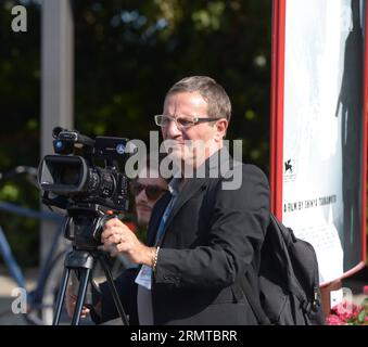 (140827) -- VENEDIG, 27. August 2014 -- Ein Journalist kommt zur Eröffnungszeremonie des 71. Internationalen Filmfestivals von Venedig auf der Lido-Insel Venedig, Italien, 27. August 2014. Das Filmfestival begann am Mittwoch. ) ITALIEN-VENEDIG-FILM FESTIVAL-OPENING-PEOPLE LiuxLihang PUBLICATIONxNOTxINxCHN Venedig Aug 27 2014 ein Journalist kommt zur Eröffnungszeremonie des 71. Internationalen Filmfestivals von Venedig AUF dem Lido Island von Venedig Italien Aug 27 2014 das Filmfestival startete AM Mittwoch Italien Venedig Film Festival Opening Prominrities PUBLICATIONxNOTxINxCHN Stockfoto