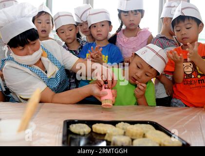 Kinder lernen unter der Leitung eines Bäckers in Hefei, der Hauptstadt der ostchinesischen Provinz Anhui, Mondkuchen zu machen, 4. September 2014. Das Mid-Autumn Festival, das in diesem Jahr am 8. September stattfindet, ist ein traditionelles chinesisches fest für Familientreffen, bei dem die Leute den Vollmond gemeinsam genießen und Mondkuchen essen - kleine runde Kuchen mit einer Vielzahl von Füllungen. )(wjq) CHINA-ANHUI-HEFEI-MOONCAKE (CN) LiuxJunxi PUBLICATIONxNOTxINxCHN Kinder lernen unter der Führung eines Bäckers in Hefei Hauptstadt der ostchinesischen Provinz Anhui AM 4. September 2014 das Mid Autumn Festival, das AM September fällt Stockfoto