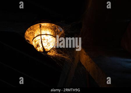 Straßenlaterne mit Spinnweben in einer überdachten Brücke Stockfoto