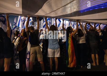 Menschen, die ein riesiges Banner bei einer Demonstration gegen Netanjahus Regierung halten. Tel Aviv, Israel. August 2023. Stockfoto