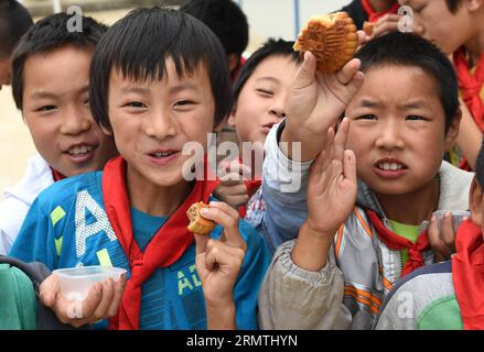 (140906) -- LUDIAN, 5. September 2014 -- Kinder zeigen ihre Mondkuchen bei der vorübergehenden Neuansiedlung in der vom Beben heimgesuchten Longtoushan Township im Ludian County, Provinz Yunnan im Südwesten Chinas, 5. September 2014. Das Mid-Autumn Festival, das in diesem Jahr am 8. September stattfindet, ist ein traditioneller chinesischer Feiertag, an dem sich Familien unter Vollmond wiedervereinigen und Mondkuchen essen. Ein Erdbeben von 6,5 Magnitude erschütterte Ludian am 3. August, wobei mehr als 600 Menschen getötet und 80.000 Häuser zerstört wurden. ) (Ry) CHINA-YUNNAN-LUDIAN-MID-HERBSTFESTIVAL (CN) LinxYiguang PUBLICATIONxNOTxINxCHN 5. September 2014 Kinder zeigen ihren Mond ca. Stockfoto