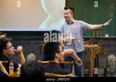 (140908) -- PEKING, 8. September 2014 -- Kunstlehrer Wu Di gibt die erste Klasse dieses Semesters an seine Studenten an der Experimental High School der Beijing Nomral University in Peking, Hauptstadt Chinas, 3. September 2014. Wu Di ist gelernter Kunstlehrer und arbeitet an der Experimental High School der Beijing Normal University. Währenddessen ist Wu, der in einer Vielzahl traditioneller chinesischer Künste versiert ist, als Meister der Malklasse Cheng Guan Tang und ein Superstar des Storytelling-Hauses Cheng Shu Guan bekannt. Wu studierte traditionelle chinesische Malerei an der Universität und hat ein d Stockfoto