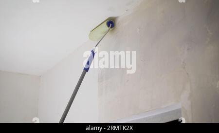 Die Grundierlösung wird mit einer Walze auf die Wand aufgetragen, um Staub zu entfernen und die Haftung zu erhöhen. Primer-Behandlung. Der Prozess der Anwendung eines Stockfoto