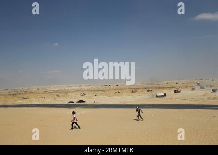 (140911) -- ISMAILIA, 11. September 2014 -- zwei ägyptische Kinder spielen in der Nähe einer Baustelle des Modernisierungsprojekts des Sueskanals in Ismailia, Ägypten, 7. September 2014. Ägypten plante den Bau eines neuen 72 Kilometer langen Kanals entlang des ursprünglichen Suez-Kanals. Die neue Wasserstraße soll dazu beitragen, die angeschlagene ägyptische Wirtschaft wiederzubeleben, indem sie die Einnahmen aus dem Schiffsverkehr erhöht, riesige ausländische Investitionen anlockt und Tausende von Arbeitsplätzen schafft. ) ÄGYPTEN-ISMAILIA-SUEZ CANAL-UPGRADE-BAU CuixXinyu PUBLICATIONxNOTxINxCHN Ismailia 11. September 2014 zwei ägyptische Kinder spielen in der Nähe einer Baustelle des Stockfoto