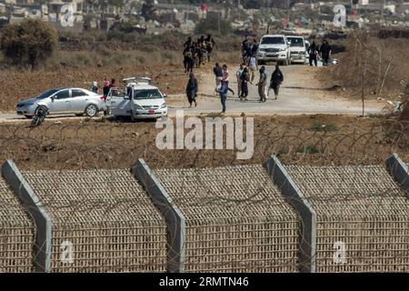 (140912) -- GOLANHÖHEN, 11. September 2014 -- Militante stehen neben Fahrzeugen, die inhaftierte UN-Friedenstruppen aus Fidschi transportieren, bevor sie am 11. September 2014 in der Nähe einer UN-Basis in Syrien auf den Golanhöhen freigelassen werden. UN-Generalsekretär Ban Ki-moon begrüßte am Donnerstag die Freilassung von 45 Fidschi-Friedenstruppen, die zwei Wochen lang auf den Golanhöhen inhaftiert waren. Die Vereinten Nationen sagten am Donnerstag, dass die Fidschianer um 14.30 Uhr Ortszeit der Beobachtertruppe der Vereinten Nationen für die Truppenentflechtung (UNDOF) übergeben wurden. Alle 45 Friedenssicherungskräfte sind in gutem Zustand und werden einer medizinischen Untersuchung unterzogen. ) MIDEAST-GOLAN-HÖHEN-DETA Stockfoto