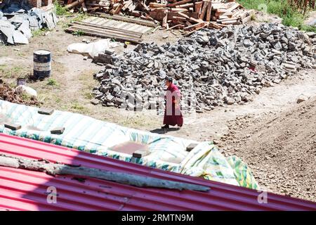 (140912) -- XIAHE, 12. September 2014 -- Ein tibetisch-buddhistischer Mönch geht durch die Stätte eines Renovierungsprogramms in der Residenz des ersten Jamyang Shepa, Gründers des Labrang-Klosters, im Xiahe County der tibetischen Autonomen Präfektur Gannan in der Provinz Gansu im Nordwesten Chinas, 2. September 2014. Das Labrang-Kloster, ein bedeutendes tibetisches buddhistisches Kloster in China, wird derzeit dem größten Renovierungsprogramm seit seiner Gründung im Jahr 1709 unterzogen. Mit der im April 2013 begonnenen Renovierung sollen die im Laufe der Jahre abgenutzten Stein- und Holzbauten im Kloster ersetzt werden. Stockfoto