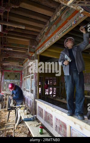 (140912) -- XIAHE, 12. September 2014 -- Arbeiter reparieren Holzkonstruktionen in der Residenz des ersten Jamyang Shepa, Gründers des Labrang-Klosters, im Xiahe County der tibetischen Autonomen Präfektur Gannan in der nordwestchinesischen Provinz Gansu, 2. September 2014. Das Labrang-Kloster, ein bedeutendes tibetisches buddhistisches Kloster in China, wird derzeit dem größten Renovierungsprogramm seit seiner Gründung im Jahr 1709 unterzogen. Mit der im April 2013 begonnenen Renovierung sollen die im Laufe der Jahre abgenutzten Stein- und Holzbauten im Kloster ersetzt werden. Das Kloster Labrang ist bis heute geöffnet Stockfoto