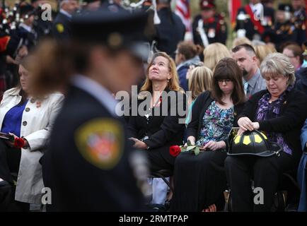 Familienmitglieder kämpfen am 14. September 2014 im Canadian Firefighter Memorial in Ottawa (Kanada) gegen Tränen. Die jährliche Veranstaltung zieht Hunderte von Feuerwehrleuten aus dem ganzen Land an, um ihre gefallenen Kollegen zu ehren und ihre Namen zu sehen, die zu den jetzt 1200 hinzugefügt werden, die das Denkmal zieren. ) CANADA-OTTAWA-FIREFIGHTER-MEMORIAL ColexBurston PUBLICATIONxNOTxINxCHN Family Members Fight Back Tears AT the Canadian Fire Fighter Memorial in Ottawa Canada AM 14. September 2014 zieht die jährliche Veranstaltung Hunderte von Feuerwehrleuten aus dem ganzen Land an, um ihre Herbstkollegen und Lake zu ehren, deren Namen dem Now hinzugefügt wurden Stockfoto