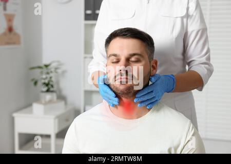 Endokrinologe zur Untersuchung der Schilddrüse des Patienten im Krankenhaus, Nahaufnahme Stockfoto