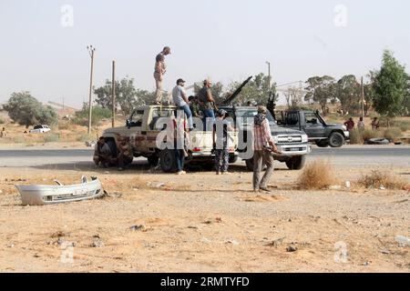 (140923) -- TRIPOLI, 23. September 2014 -- am 23. September 2014 warten mehrere Libyen-Dawn-Kämpfer in der Region Wershfana in Tripoli, Libyen, auf Befehle neben bewaffneten LKWs. Schwere Auseinandersetzungen zwischen Kämpfern der Libyschen Morgenröte und lokalen Milizen setzten sich am Dienstag in der Region Wershfana in Tripolis fort. Libyen hat seit Mai eine drastische Eskalation der Gewalt erlebt, als es zu tödlichen Zusammenstößen zwischen den islamistischen Militanten des Landes und prosäkularen Milizen kam. Die schweren Kämpfe brennen immer noch in anderen Städten wie Bengasi, Gharyan. LIBYEN-TRIPOLI-ZUSAMMENSTÖSSE HamzaxTurkia PUBLICATIONxNOTxINxCHN Tripoli 23. September 2014 mehrere Libyen Stockfoto