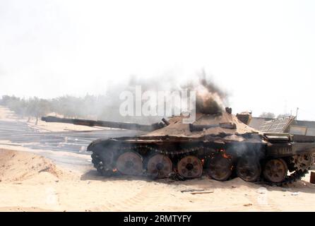 (140923) -- TRIPOLI, 23. September 2014 -- Ein Tank der Libyschen Morgenröte ist mit Sand bedeckt, um am 23. September 2014 in der Wershfana-Region in Tripoli, Libyen, Feuer zu löschen. Schwere Auseinandersetzungen zwischen Kämpfern der Libyschen Morgenröte und lokalen Milizen setzten sich am Dienstag in der Region Wershfana in Tripolis fort. Libyen hat seit Mai eine drastische Eskalation der Gewalt erlebt, als es zu tödlichen Zusammenstößen zwischen den islamistischen Militanten des Landes und prosäkularen Milizen kam. Die schweren Kämpfe brennen immer noch in anderen Städten wie Bengasi, Gharyan. LIBYEN-TRIPOLI-ZUSAMMENSTÖSSE HamzaxTurkia PUBLICATIONxNOTxINxCHN Tripoli 23. September 2014 ein Libyen-Dämmerungspanzer Stockfoto