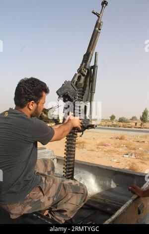 (140923) -- TRIPOLI, 23. September 2014 -- Ein Libyen-Dawn-Kämpfer lädt das Maschinengewehr in der Wershfana-Region in Tripoli, Libyen, am 23. September 2014 um. Schwere Auseinandersetzungen zwischen Kämpfern der Libyschen Morgenröte und lokalen Milizen setzten sich am Dienstag in der Region Wershfana in Tripolis fort. Libyen hat seit Mai eine drastische Eskalation der Gewalt erlebt, als es zu tödlichen Zusammenstößen zwischen den islamistischen Militanten des Landes und prosäkularen Milizen kam. Die schweren Kämpfe brennen immer noch in anderen Städten wie Bengasi, Gharyan. LIBYEN-TRIPOLIS-ZUSAMMENSTÖSSE HamzaxTurkia PUBLICATIONxNOTxINxCHN Tripoli 23. September 2014 A Libya Dawn Fighter Reload T Stockfoto