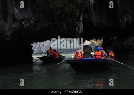 (140925) -- HA LONG BAY, 24. September 2014 -- Boote segeln durch Bögen am Boden der Inseln in Ha Long Bay, Nordvietnam, 24. September 2014. Die ha Long Bay im Golf von Tonkin umfasst etwa 1.600 Inseln und Inselchen und bildet eine spektakuläre Meereslandschaft aus Kalksteinsäulen. Aufgrund ihrer steilen Natur sind die meisten Inseln unbewohnt und nicht von einer menschlichen Präsenz betroffen. Die außergewöhnliche landschaftliche Schönheit der Stätte wird durch ihr großes biologisches Interesse ergänzt. Sie wurde 1994 in die UNESCO-Weltnaturerbe-Liste aufgenommen. VIETNAM-HA LONG BAY-WELTKULTURERBE ZHANGXJIANHUA PUBLICATIONXN Stockfoto