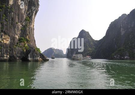 (140925) -- HA LONG BAY, 24. September 2014 -- Boote segeln durch Wasserstraßen zwischen den Inseln und Inselchen in Ha Long Bay, Nordvietnam, 24. September 2014. Die ha Long Bay im Golf von Tonkin umfasst etwa 1.600 Inseln und Inselchen und bildet eine spektakuläre Meereslandschaft aus Kalksteinsäulen. Aufgrund ihrer steilen Natur sind die meisten Inseln unbewohnt und nicht von einer menschlichen Präsenz betroffen. Die außergewöhnliche landschaftliche Schönheit der Stätte wird durch ihr großes biologisches Interesse ergänzt. Sie wurde 1994 in die UNESCO-Weltnaturerbe-Liste aufgenommen. VIETNAM-HA LONG BAY-WELTKULTURERBE ZHANGXJIANHUA PUBLICA Stockfoto