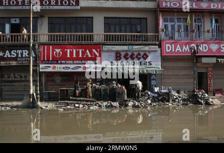 (140925)- SRINAGAR, 25. September 2014 - Kaschmirfrau läuft an Warenrettungen in einem beschädigten Markt durch die jüngsten Überschwemmungen in Srinagar, Sommerhauptstadt des von Indien kontrollierten Kaschmirs, 25. September 2014 vorbei. Die Regierung des von Indien kontrollierten Kaschmirs wird der indischen Regierung wahrscheinlich eine Verlustvereinbarung vorlegen, die sich in der kommenden Woche auf mindestens 50.000 Cr indische Rupien belaufen wird. Die Rekordfluten in über einem Jahrhundert, die von Indianern kontrolliertes Kaschmir getroffen haben, haben Hunderte von Menschen getötet und Zehntausende obdachlos gemacht. ) INDIEN-KASCHMIR-SRINAGAR-HOCHWASSER NACH JavedxDar PUBLICATIONxNOTxINxCHN Srinagar 25. September 2 Stockfoto