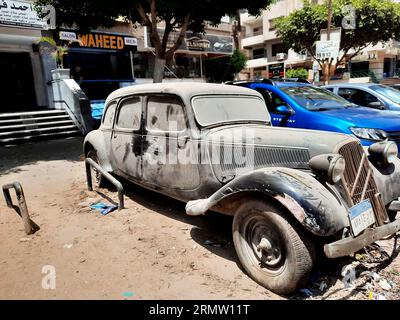 Kairo, Ägypten, 1. August 2023: Altes, altmodisches Fahrzeug im Retro-Stil auf der Straße geparkt, mit neuen Buchstaben und Zahlen auf dem ägyptischen Verkehrsschild; Stockfoto