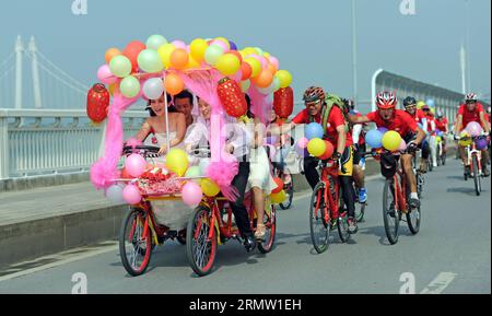 Braut Jiang Yan und Bräutigam Huang Bo fahren mit einem Allrad-Hochzeitsfahrrad in Changsha, der Hauptstadt der zentralchinesischen Provinz Hunan, am 27. September 2014. Das Paar feierte zusammen mit ihren Reitkollegen am Samstag ihre Hochzeit mit Fahrrädern. (wyl) CHINA-CHANGSHA-ROMANTIK AUF DEM FAHRRAD (CN) LixGa PUBLICATIONxNOTxINxCHN Braut Jiang Yan und BRÄUTIGAM Huang Bo reiten ein Allrad-HOCHZEITSFAHRRAD in Changsha Hauptstadt der zentralchinesischen Provinz S Hunan September 27 2014 das PAAR feierte zusammen mit ihren Reitgenossen ihre Hochzeit mit Fahrrädern AM Samstag China Changsha Romance AUF BICYC Stockfoto