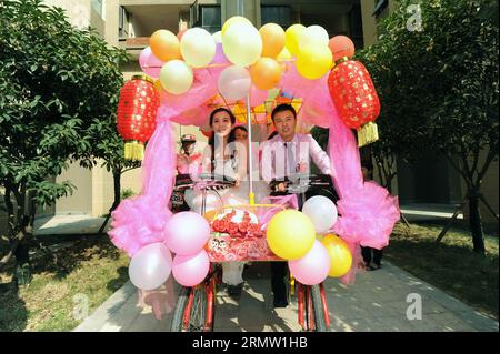 Braut Jiang Yan und Bräutigam Huang Bo fahren mit einem Allrad-Hochzeitsfahrrad in Changsha, der Hauptstadt der zentralchinesischen Provinz Hunan, am 27. September 2014. Das Paar feierte zusammen mit ihren Reitkollegen am Samstag ihre Hochzeit mit Fahrrädern. (wyl) CHINA-CHANGSHA-ROMANTIK AUF DEM FAHRRAD (CN) LixGa PUBLICATIONxNOTxINxCHN Braut Jiang Yan und BRÄUTIGAM Huang Bo reiten ein Allrad-HOCHZEITSFAHRRAD in Changsha Hauptstadt der zentralchinesischen Provinz S Hunan September 27 2014 das PAAR feierte zusammen mit ihren Reitgenossen ihre Hochzeit mit Fahrrädern AM Samstag China Changsha Romance AUF BICYC Stockfoto