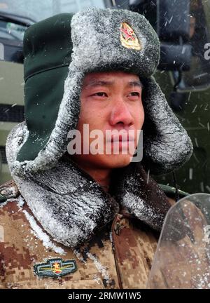 Ein Soldat eines LKW-Transportregiments des Qinghai-Tibet-Korps steht unter Schnee auf einem Parkplatz der Militärdienststelle am Tuotuo River am Qinghai-Tibet Highway, südwestchinesische Autonome Region Tibet, 26. September 2014. Die Transportregimenter des Qinghai-Tibet-Korps der chinesischen Volksbefreiungsarmee (PLA) führen seit 1954 Frachttransporte für PLA-Truppen in Tibet durch. 60 Jahre lang transportierten sie mehr als 800 Tonnen Material, was etwa 80 Prozent der Truppentransporte auf dem Qinghai-Tibet-Plateau erbrachte. (lfj) CHINA-T Stockfoto