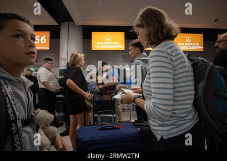 Junge Familie, die ihr Gepäck vor dem Flug mit der EasyJet Low-Cost-Fluggesellschaft am Abflugterminal von Gatwick North abgibt Stockfoto