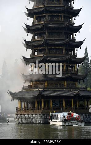 (141001) -- GUILIN, 1. Oktober 2014 -- Foto aufgenommen am 1. Oktober 2014 zeigt die Sonnenpagode, die im Tannensee in Guilin, der südchinesischen autonomen Region Guangxi Zhuang, Feuer fängt. Die bronzefarbene Betonpagode, die 41 Meter hoch war und aus 350 Tonnen Bronze bestand, fing am Mittwochmorgen Feuer. Die Feuerwehrleute setzten das Feuer ab, das mehr als zwei Stunden gedauert hatte. Die Doppelpagoden, genannt Sonne und Mond im Tannensee, wurden 2001 auf der Grundlage von etwas aus der Tang-Dynastie (618-907 n. Chr.) wiederaufgebaut. Sie gehören zu den touristischen Sehenswürdigkeiten von Guilin. ) (lfj) CHI Stockfoto