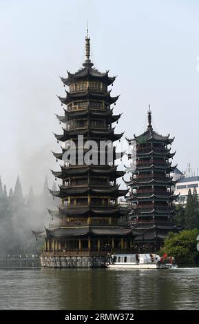 (141001) -- GUILIN, 1. Oktober 2014 -- Foto aufgenommen am 1. Oktober 2014 zeigt die Sonnenpagode, die im Tannensee in Guilin, der südchinesischen autonomen Region Guangxi Zhuang, Feuer fängt. Die bronzefarbene Betonpagode, die 41 Meter hoch war und aus 350 Tonnen Bronze bestand, fing am Mittwochmorgen Feuer. Die Feuerwehrleute setzten das Feuer ab, das mehr als zwei Stunden gedauert hatte. Die Doppelpagoden, genannt Sonne und Mond im Tannensee, wurden 2001 auf der Grundlage von etwas aus der Tang-Dynastie (618-907 n. Chr.) wiederaufgebaut. Sie gehören zu den touristischen Sehenswürdigkeiten von Guilin. ) (lfj) CHI Stockfoto