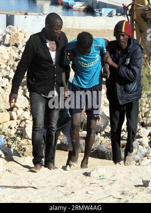 GARABULLI, 2. Oktober 2014 -- zwei illegale Einwanderer unterstützen einen ihrer verwundeten Gefährten in Garabulli, Libyen, am 2. Oktober 2014. Die libysche Küstenwache hat am Donnerstag rund 190 illegale Einwanderer in der Nähe der Küstenstadt Garabulli, etwa 60 Kilometer von Tripoli entfernt, gerettet. Libyen ist seit langem ein Transitort für Migranten, die Malta, Italien und andere Orte in Europa erreichen wollen, da es in der Nähe liegt und die Grenzen relativ locker sind. ) LIBYEN-GARABULLI-ILLEGALE EINWANDERER HamzaxTurkia PUBLICATIONxNOTxINxCHN OKT 2 2014 zwei illegale Einwanderer unterstützen einen ihrer verwundeten Begleiter in Libyen AM 2. OKT Stockfoto