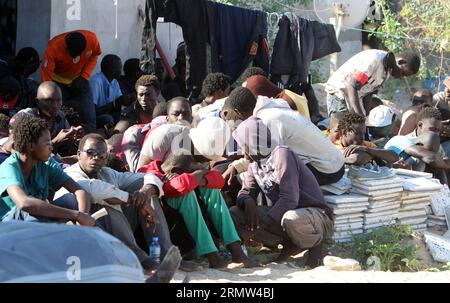 GARABULLI, 2. Oktober 2014 -- einige illegale Einwanderer sitzen in einem Hof in Garabulli, Libyen, am 2. Oktober 2014. Die libysche Küstenwache hat am Donnerstag rund 190 illegale Einwanderer in der Nähe der Küstenstadt Garabulli, etwa 60 Kilometer von Tripoli entfernt, gerettet. Libyen ist seit langem ein Transitort für Migranten, die Malta, Italien und andere Orte in Europa erreichen wollen, da es in der Nähe liegt und die Grenzen relativ locker sind. ) LIBYEN-GARABULLI-ILLEGALE EINWANDERER HamzaxTurkia PUBLICATIONxNOTxINxCHN OKT 2 2014 einige illegale Einwanderer sitzen in einem Yard in Libyen AM OKT 2 2014 Libyens Küstenwache AM Donnerstag gerettet Som Stockfoto