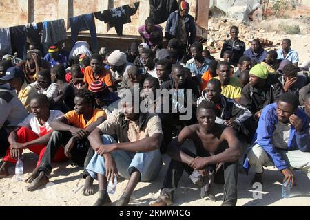 GARABULLI, 2. Oktober 2014 -- einige illegale Einwanderer sitzen in einem Hof in Garabulli, Libyen, am 2. Oktober 2014. Die libysche Küstenwache hat am Donnerstag rund 190 illegale Einwanderer in der Nähe der Küstenstadt Garabulli, etwa 60 Kilometer von Tripoli entfernt, gerettet. Libyen ist seit langem ein Transitort für Migranten, die Malta, Italien und andere Orte in Europa erreichen wollen, da es in der Nähe liegt und die Grenzen relativ locker sind. ) LIBYEN-GARABULLI-ILLEGALE EINWANDERER HamzaxTurkia PUBLICATIONxNOTxINxCHN OKT 2 2014 einige illegale Einwanderer sitzen in einem Yard in Libyen AM OKT 2 2014 Libyens Küstenwache AM Donnerstag gerettet Som Stockfoto