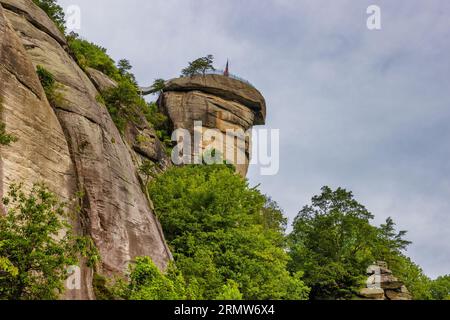 Der Gipfel des Chimney Rock im Chimney Rock State Park ist von unten unter bewölktem Himmel zu sehen. Stockfoto