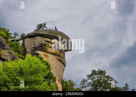 Der Gipfel des Chimney Rock im Chimney Rock State Park ist von unten unter bewölktem Himmel zu sehen. Stockfoto