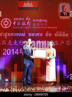 (141008) -- PHNOM PENH, 8. Oktober 2014 -- ouk Maly (R), stellvertretender Gouverneur der Nationalbank von Kambodscha, stellt Chen Changjiang, CEO der Bank of China Phnom Penh Niederlassung, in Phnom Penh, Kambodscha, am 8. Oktober 2014 eine Lizenz für den Betrieb einer Zweigstelle der Bank of China Phnom Penh Niederlassung vor. Die Bank of China Phnom Penh Zweigstelle eröffnete am Mittwoch ihre zweite Zweigstelle in Phnom Penh, der Hauptstadt Kambodschas, nachdem sie mehr als drei Jahre im Land präsent war. ) KAMBODSCHA-PHNOM PENH-BANK OF CHINA-SUB-BRANCH-OPEN Sovannara PUBLICATIONxNOTxINxCHN Phnom Penh OCT 8 2014 Maly r Stellvertretender GO Stockfoto